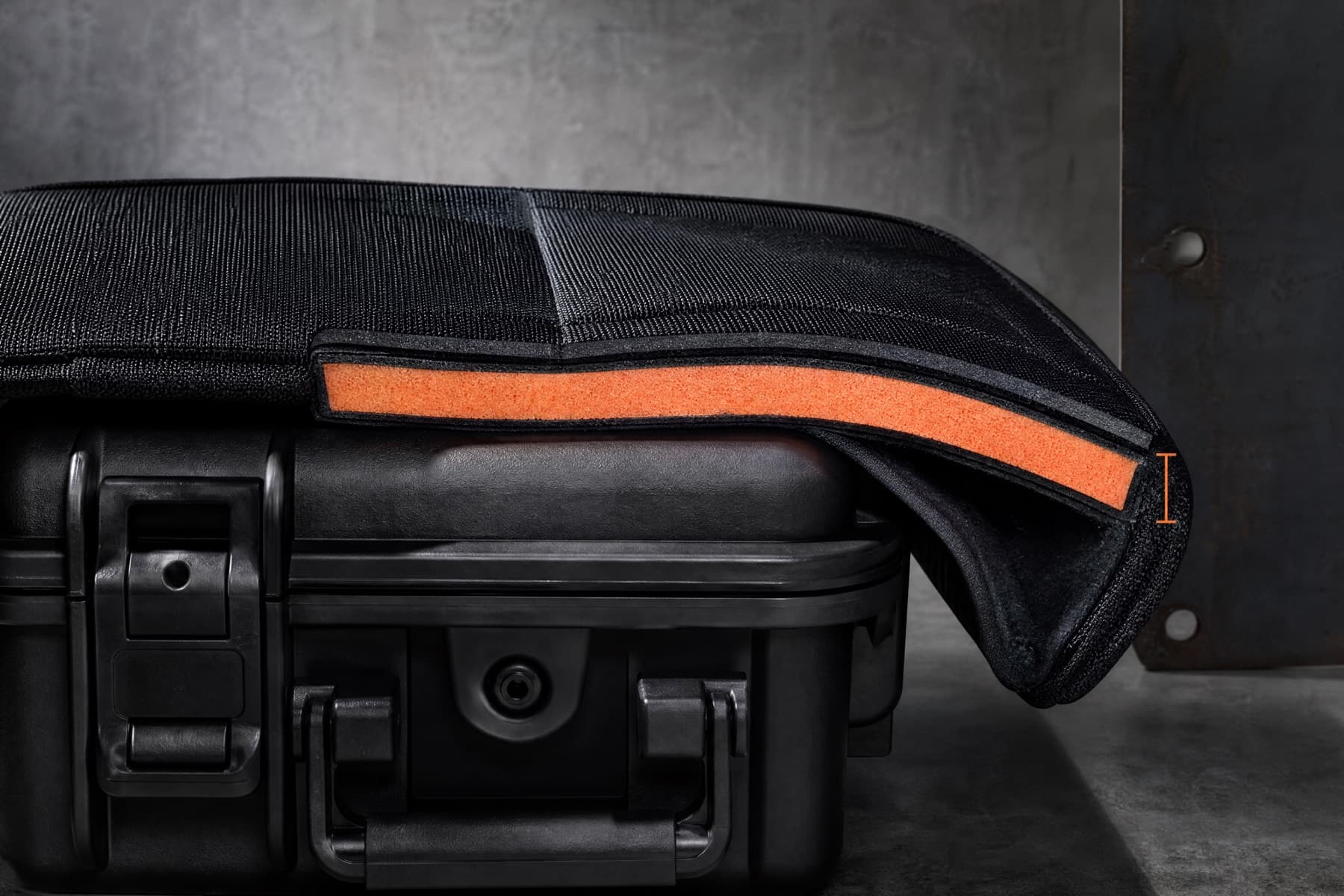 A padded cover cut open to expose the closed-cell foam core between its outer shell and lining.