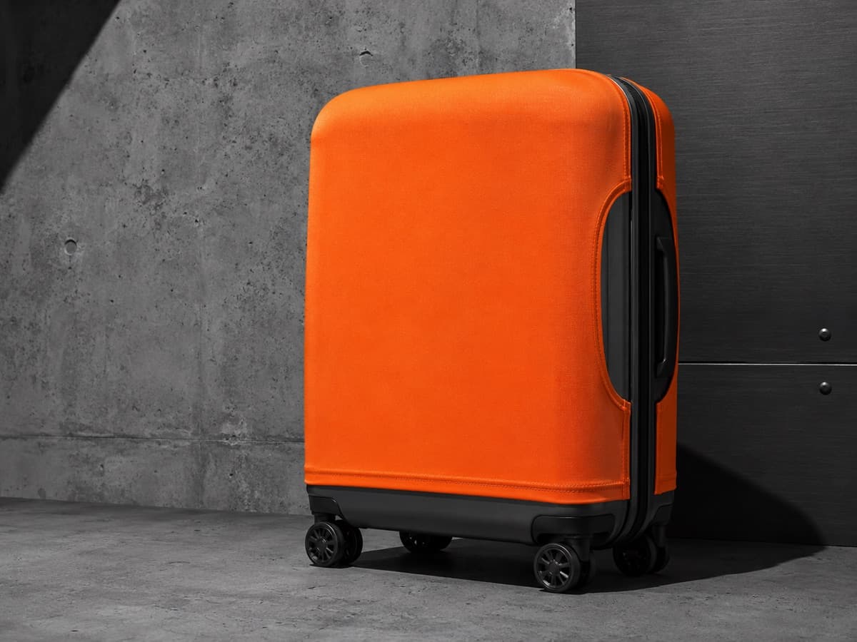 A stretch fabric cover pulled taut over a hard-shell travel case, hem gripping the shell edge.