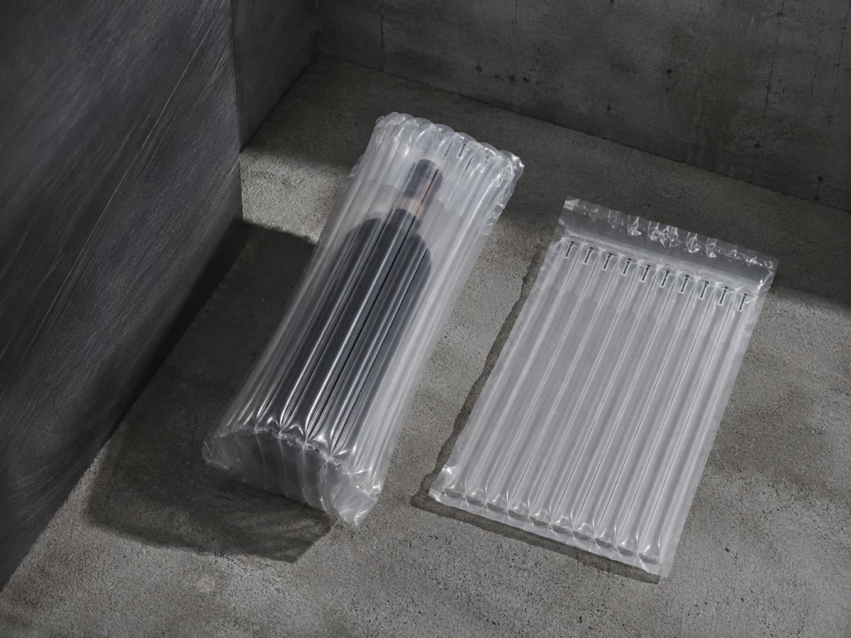An inflatable air-column sleeve holding a plain glass bottle, with a second flat sleeve beside it.