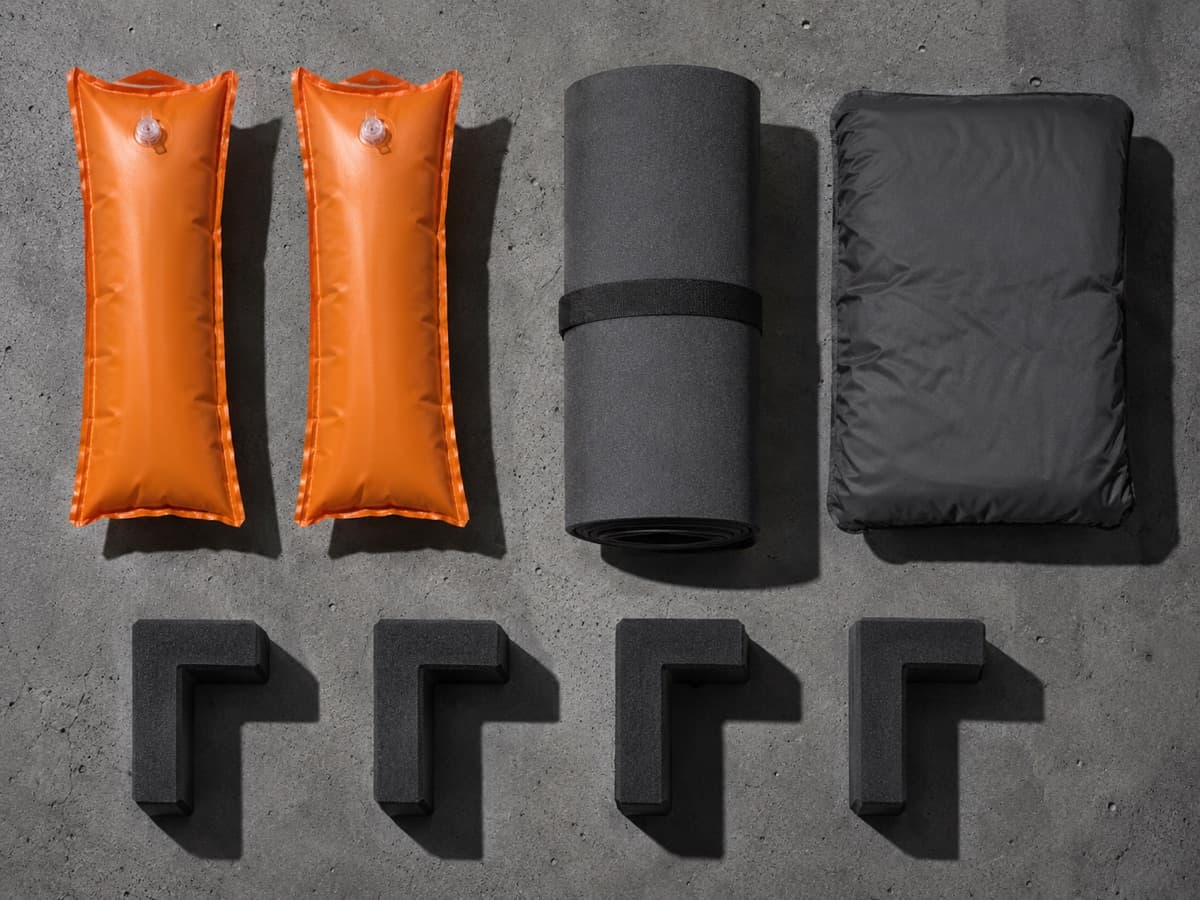 A flat-lay kit: two bottle sleeves, a roll of foam wrap, a fill pad and four corner cushions.