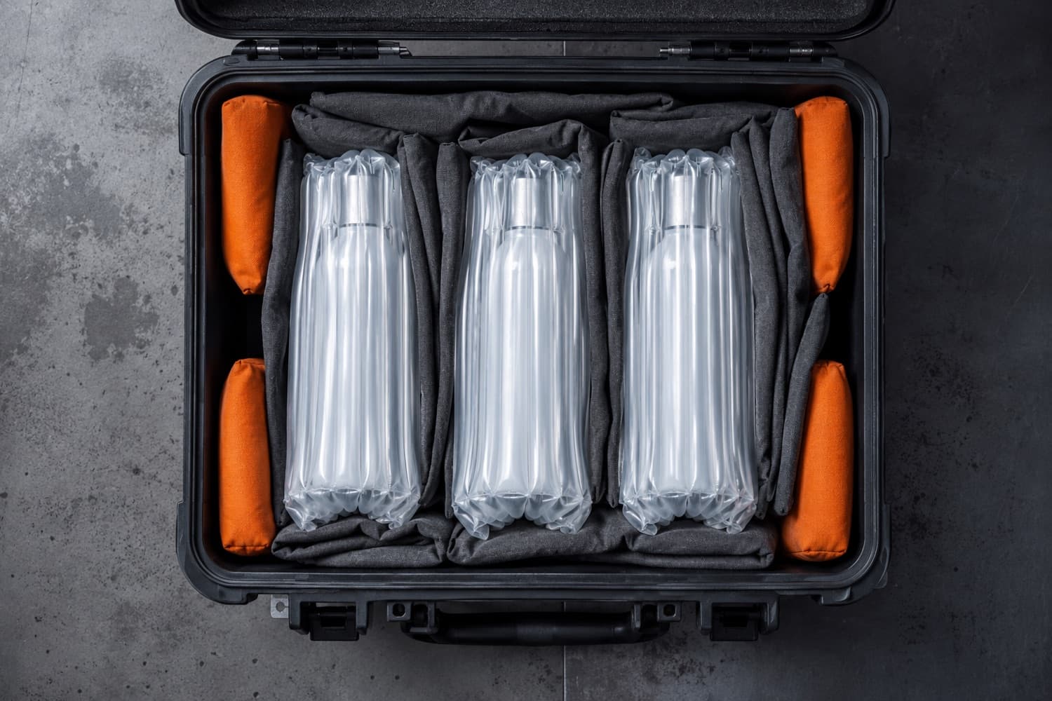 Looking into an open case: bottles in air-column sleeves with fill pads wedged into the gaps.