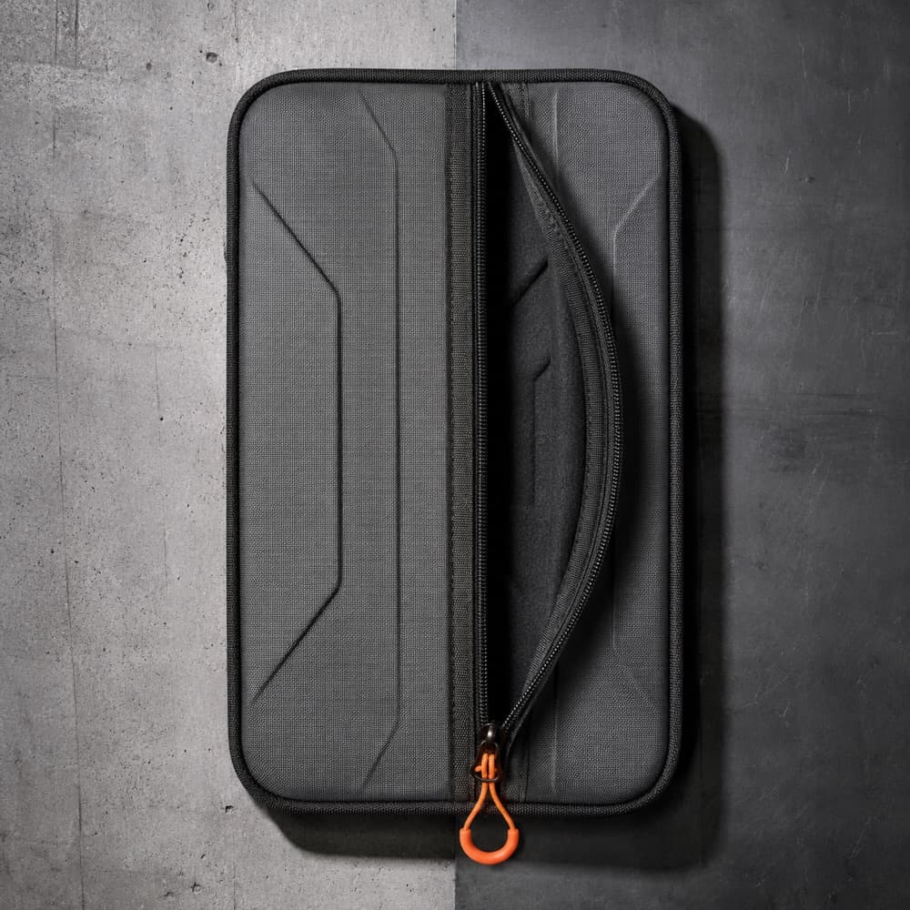 A case cover laid flat with a long side-access zipper running down it, half open.