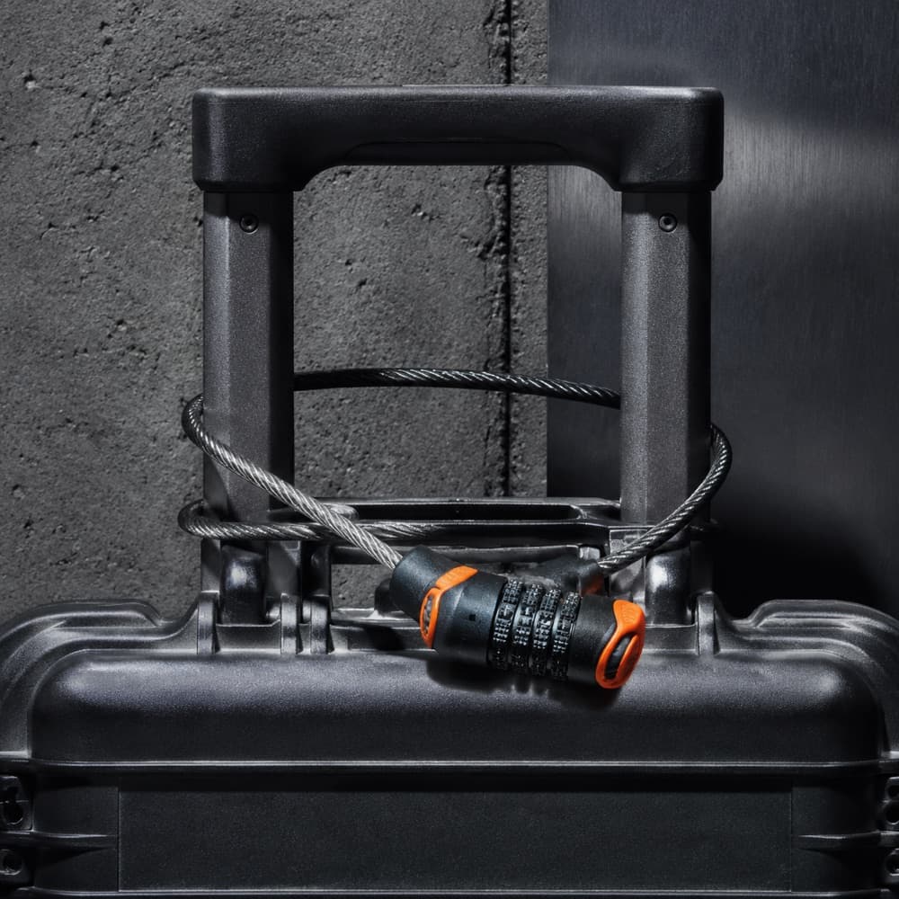 A braided steel cable lock looped once around a telescopic case handle.