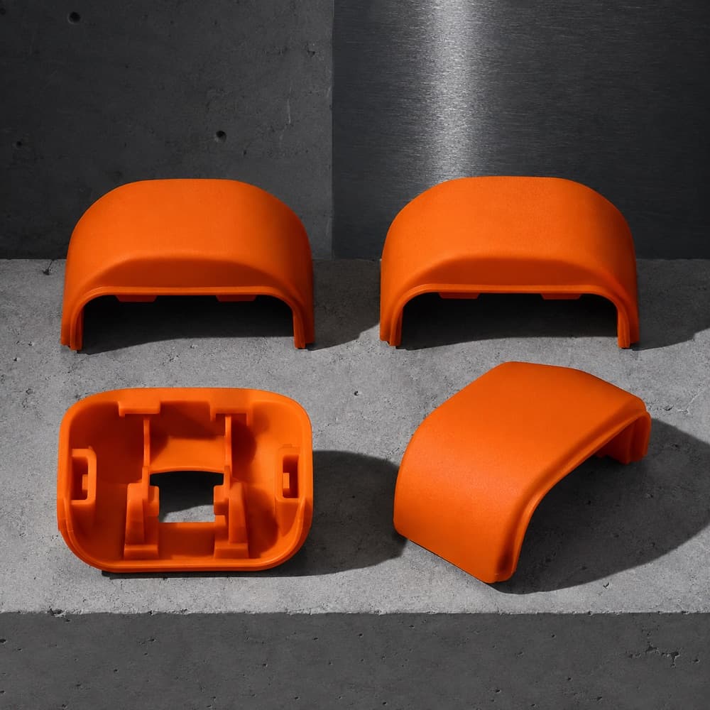 Four moulded wheel shrouds arranged in a square, one flipped to show the clip geometry.